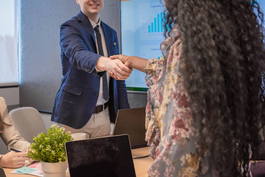 Businessman shake hands with business women agreeing on partnerships or introducing themselves