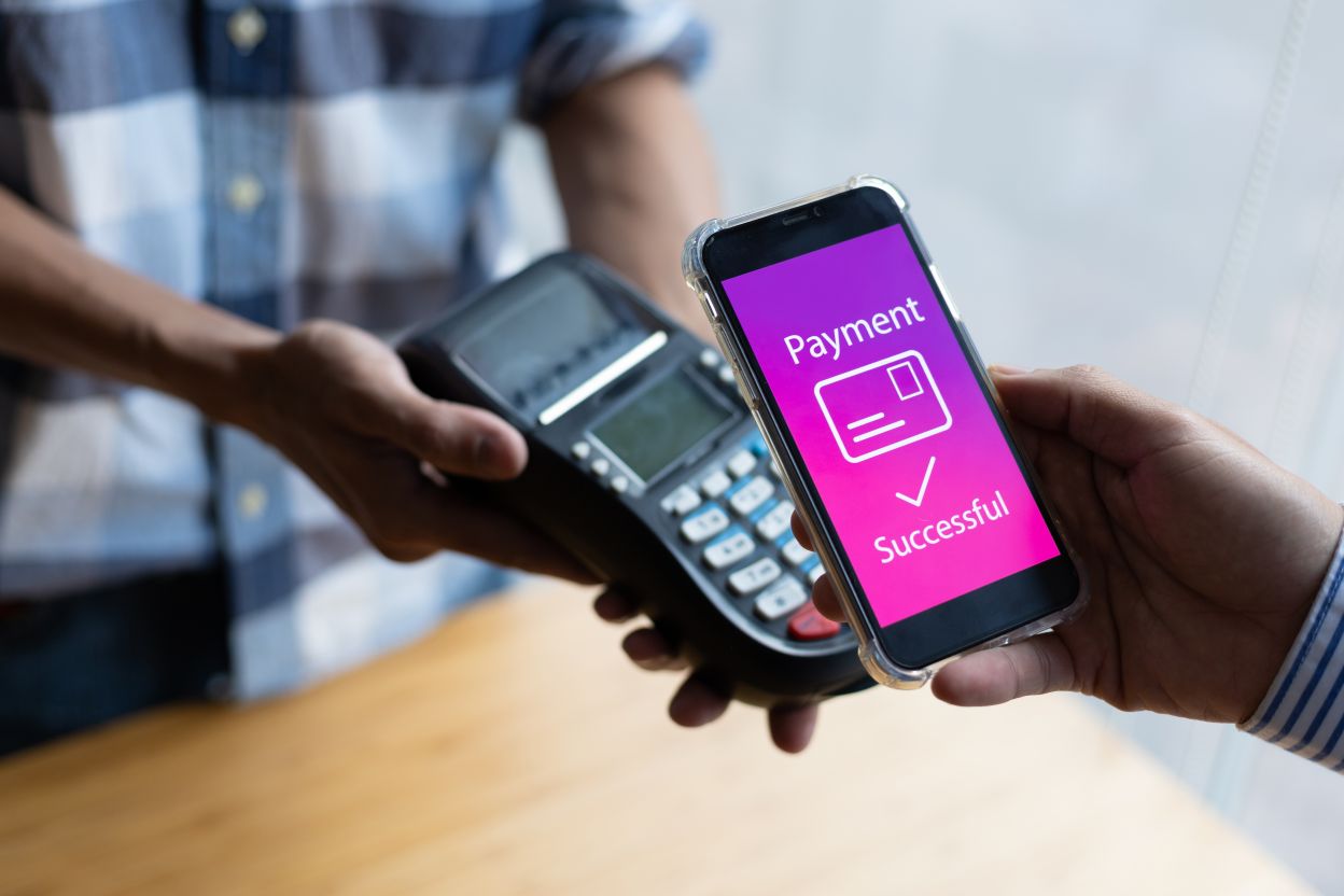 Close-up of a customer paying for goods with a mobile app on the counter