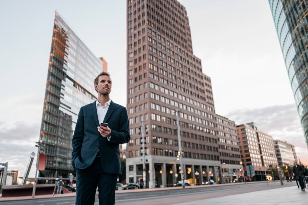 Alemania, Berl&iacute;n, empresario con smartphone de pie en Potsdamer Platz