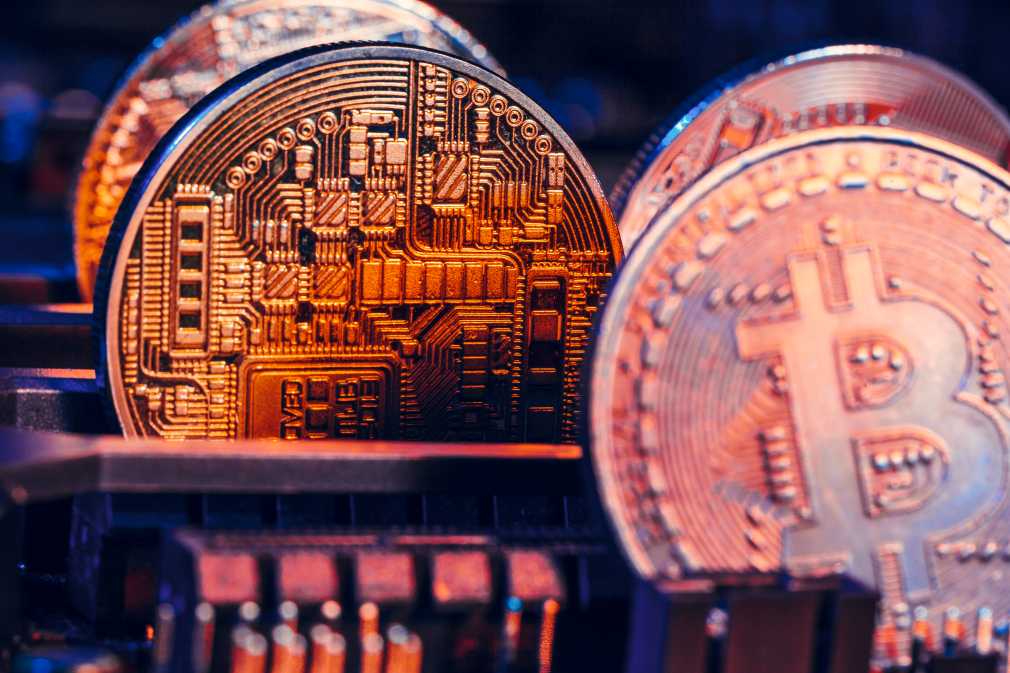 Golden bitcoin and computer chip in background