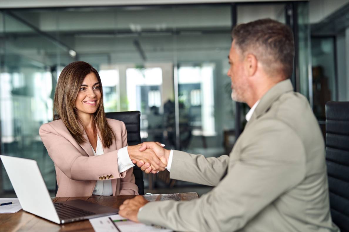 Handshake of happy professional business man and woman after deciding which between Letter of Credit vs Line of Credit is best for her business