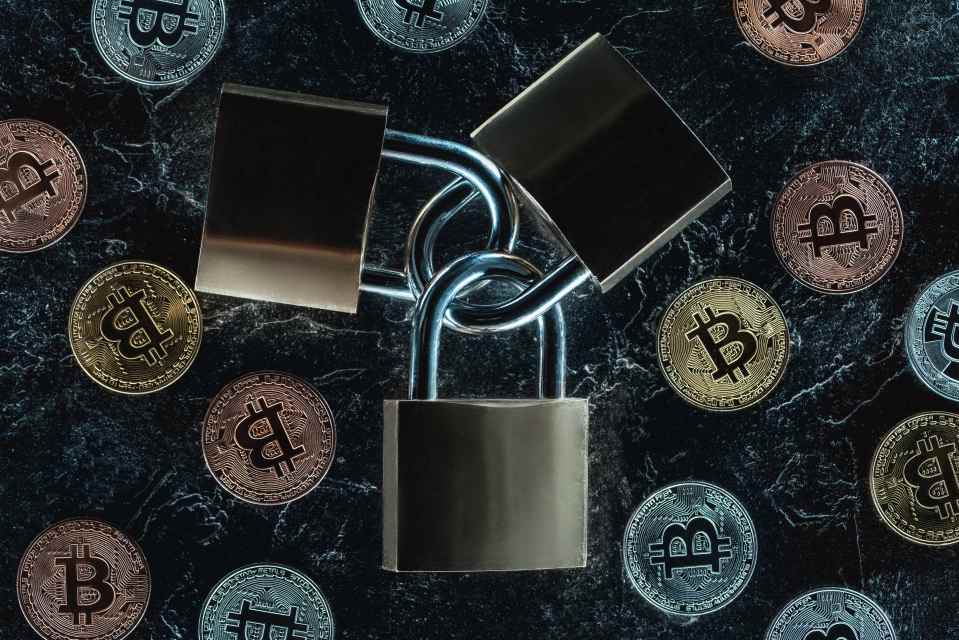 Draufsicht auf angeordnete Schl&ouml;sser und verschiedene Bitcoins auf dunkler Marmoroberfl&auml;che