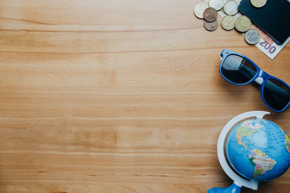 Fondo de viaje con monedas, tarjetas, tel&eacute;fono m&oacute;vil, globo y caf&eacute;. vista superior espacio vac&iacute;o para texto