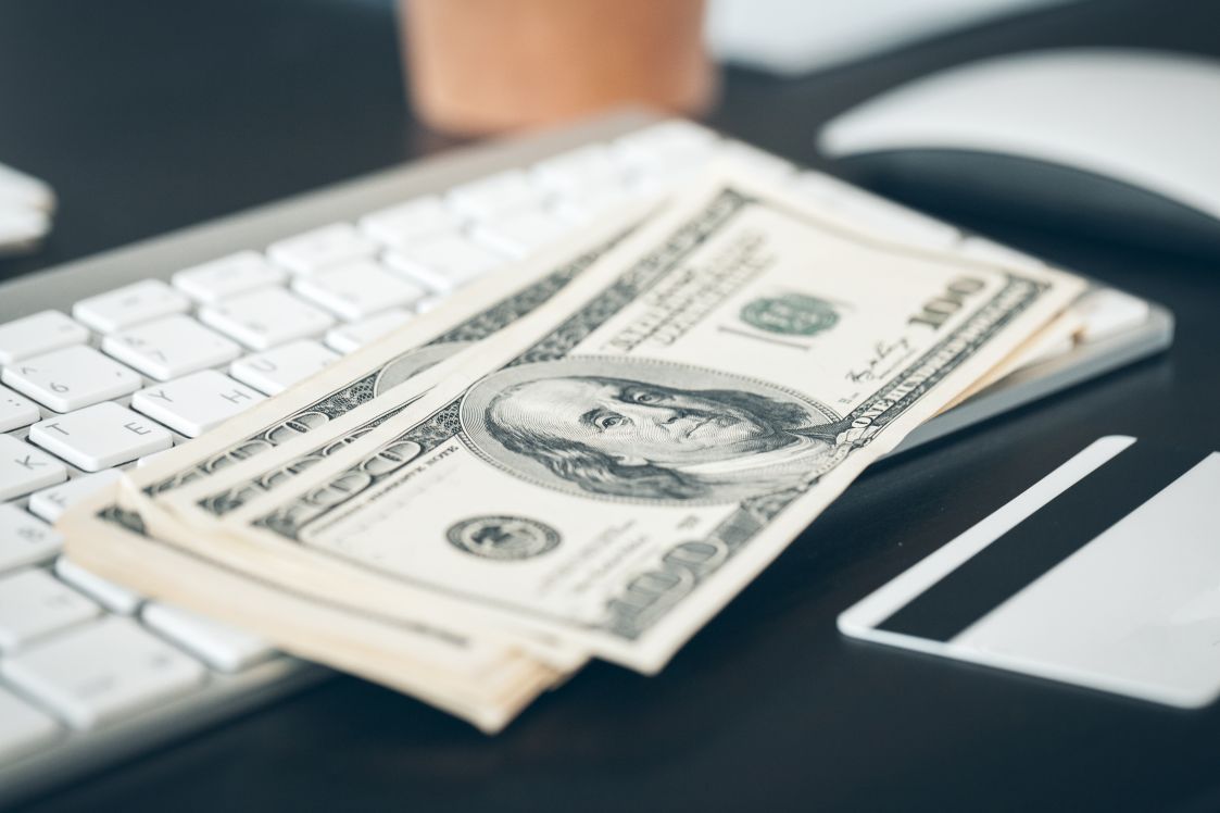 US dollar banknotes put on a computer keyboard close up