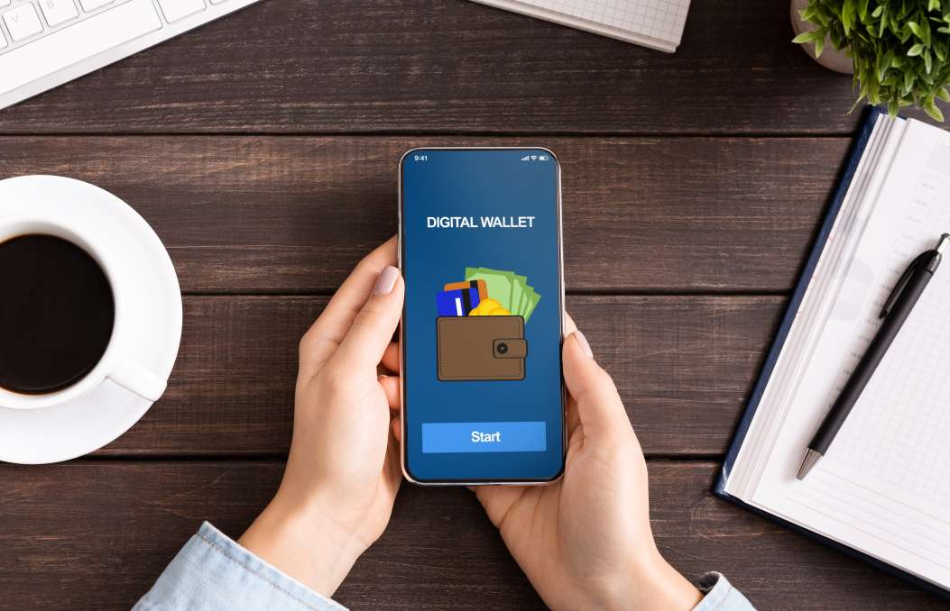 Frau, die ein Smartphone mit einer Anwendung f&uuml;r digitale Geldb&ouml;rsen h&auml;lt